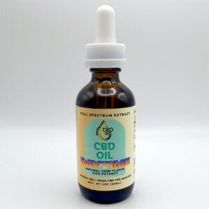 An amber glass bottle with a white dropper cap and CBD oil label sits next to CBD gummies.